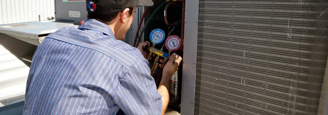 HVAC technician servicing a condenser unit in Georgetown